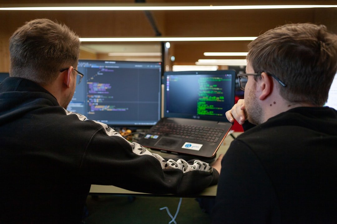 digital IT guys looking at a coding program on a laptop and monitor